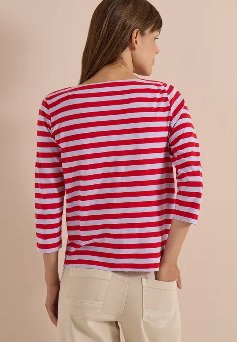 Basic Shirt mit Boat Neck und Streifen signal red Rückansicht einer Frau mit rot-weiß gestreiftem 3/4-Armshirt und hellen Hosen.