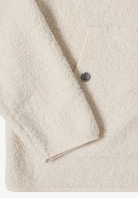Beige Sherpa-Fleecejacke mit Knopf und Reißverschlusstasche aus weichem, flauschigem Material.