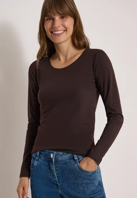 Basic Shirt mit Rundhals im 2er-Pack truffle brown/north blue Frau in dunklem Langarmshirt und Jeans, lächelt, steht mit einer Hand in der Hosentasche vor neutralem Hintergrund