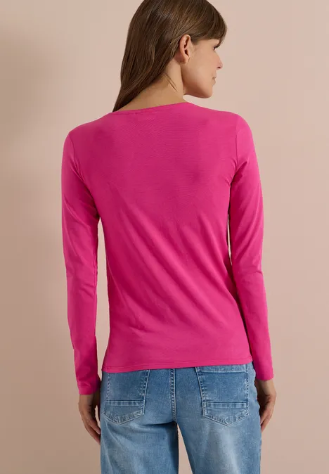 Basic Shirt mit Rundhals im 2er-Pack pink flash/truffle brown Frau von hinten in pinkem Langarmshirt und blauen Jeans vor beigem Hintergrund.