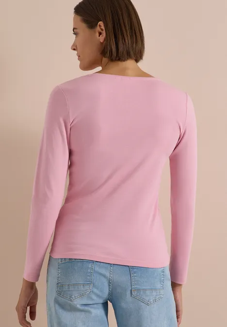 Langarm Shirt in Unifarbe mit V-Neck mellow rose Frau von hinten mit rosa Langarmshirt und blauen Jeans