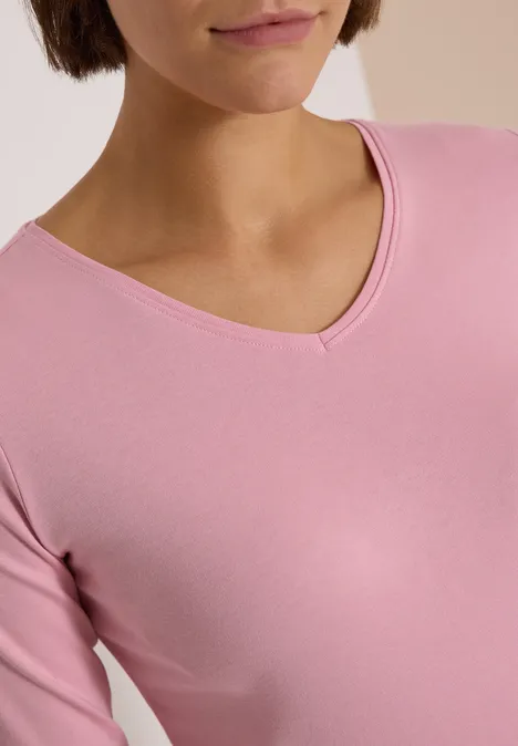 Langarm Shirt in Unifarbe mit V-Neck mellow rose Nahaufnahme einer Person im rosafarbenen V-Ausschnitt-Shirt.