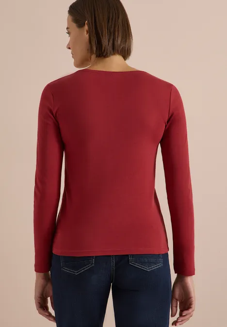 Langarm Shirt in Unifarbe mit V-Neck russet red Frau von hinten, trägt rotes Langarmshirt und Jeans vor neutralem Hintergrund