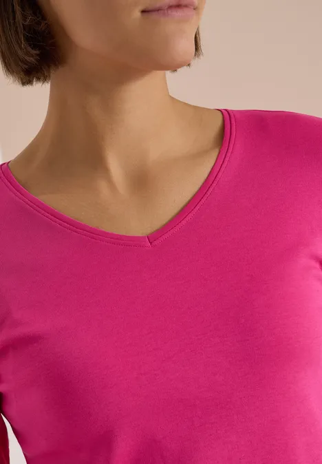Langarm Shirt in Unifarbe mit V-Neck pink flash Teilansicht einer Frau in pinkem V-Ausschnitt-Oberteil.