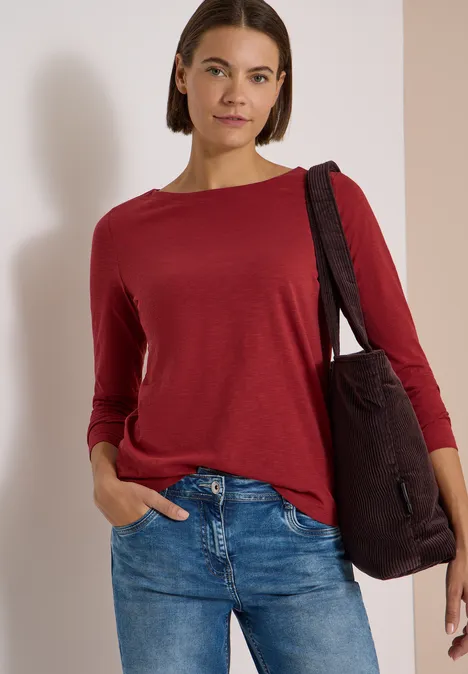 Langarm Shirt mit U-Boot-Ausschnitt russet red Frau in rotem Shirt und Jeans, lässig mit schwarzer Tasche über der Schulter.