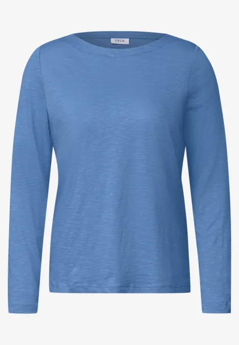 Ein einfarbiges, langärmeliges Damen-Shirt in Hellblau.