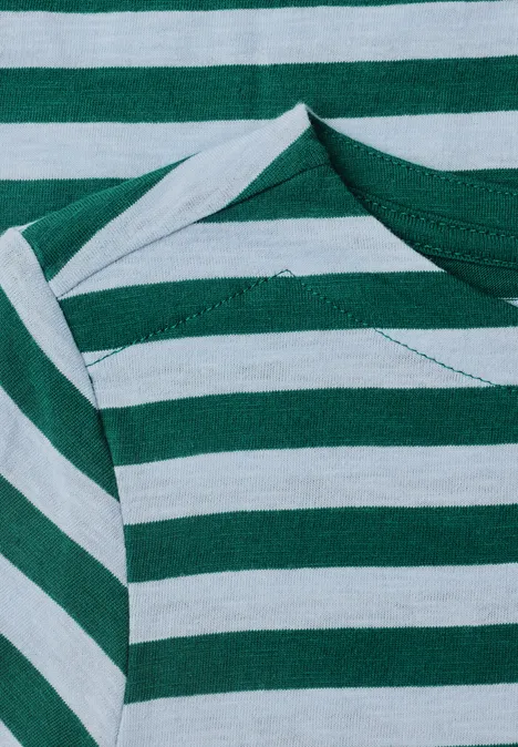 Close-up van een groen-wit gestreept T-shirt met zichtbare schoudernaden en geplooide hals.