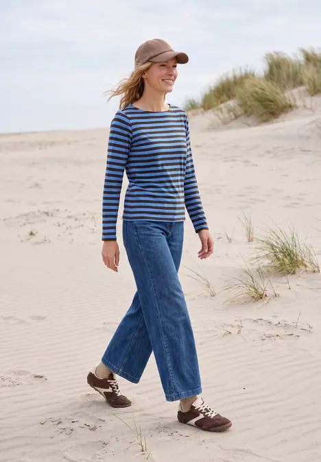 Langarm Shirt mit Boat Neck und Streifen north blue Frau in gestreiftem Shirt, Jeans und Cap spaziert entspannt über sandige Dünen an der Küste.