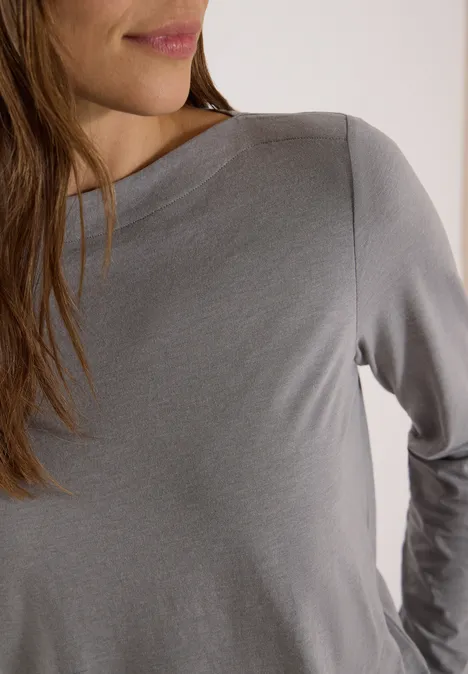 Langarm Shirt mit U-Boot-Ausschnitt concrete grey melange Vorderansicht einer Frau in grauem Langarmshirt, Oberkörper und Teil des Gesichts sichtbar.