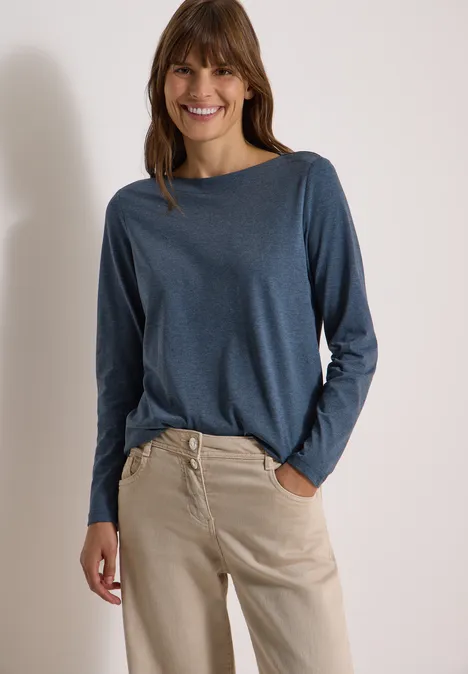 Langarm Shirt mit U-Boot-Ausschnitt moonlight blue melange Lächelnde Frau trägt blaues Langarmshirt und beige, hoch taillierte Hose.