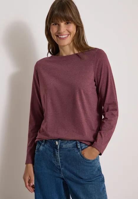 Langarm Shirt mit U-Boot-Ausschnitt red wine melange Lächelnde Frau in bordeauxrotem Langarmshirt und blauen Jeans vor hellem Hintergrund.