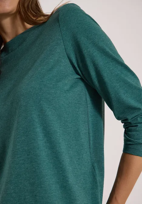 Langarm Shirt mit U-Boot-Ausschnitt dark fir green melange Person im dunkelgrünen Langarmshirt, Fokus auf Oberkörper und Arm.