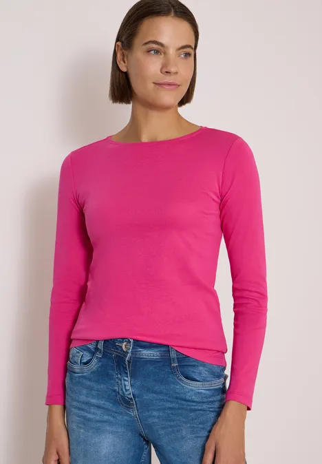 Langarm Shirt mit U-Boot-Ausschnitt pink flash Eine Frau in pinkem Langarmshirt und blauen Jeans vor hellem Hintergrund.