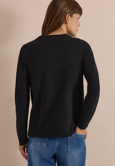 Vue de dos d’un mannequin portant un t-shirt noir à manches longues et un jean bleu.