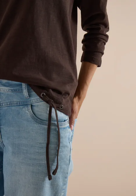 Langarm Shirt mit Rundhals und Tunnelzug truffle brown Teilansicht einer Person in braunem Langarmshirt und hellblauen Jeans mit seitlicher Schnürung.