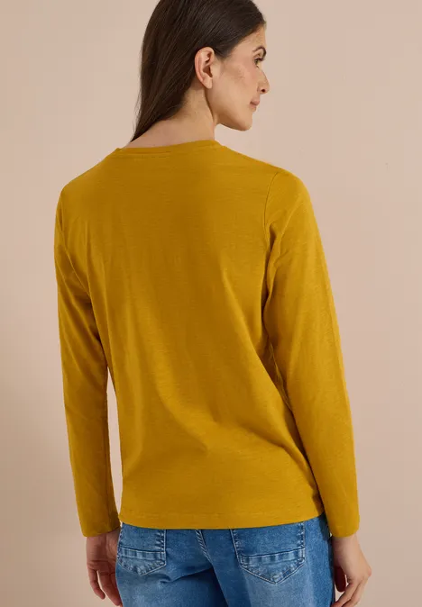 Langarm Shirt mit Rundhals und Tunnelzug golden honey Rückenansicht einer Frau in schlichtem senfgelbem Langarmshirt vor neutralem Hintergrund.