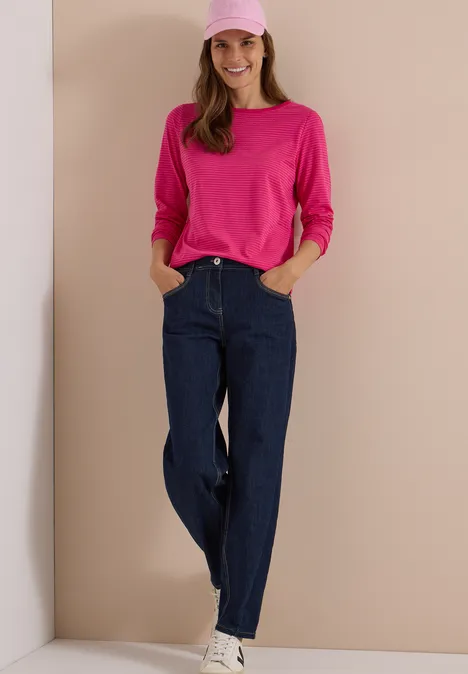 Langarm Shirt mit Boat Neck und Streifen pink flash Eine Frau in dunkelblauen Jeans, pinkem Longsleeve und rosa Mütze steht vor hellem Hintergrund und lächelt.