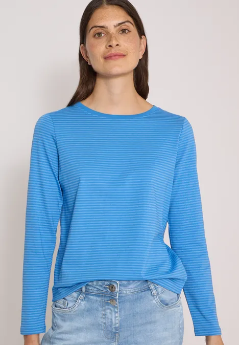 Langarm Shirt mit Boat Neck und Streifen north blue Frau in blauem Langarmshirt und Jeans vor hellem Hintergrund.