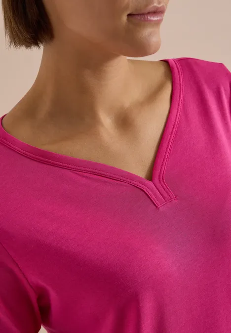 Shirt mit Split Neck im Tunika-Look pink flash Nahaufnahme einer Person im pinken V-Ausschnitt-Shirt, Gesicht und Oberkörper nur teilweise sichtbar