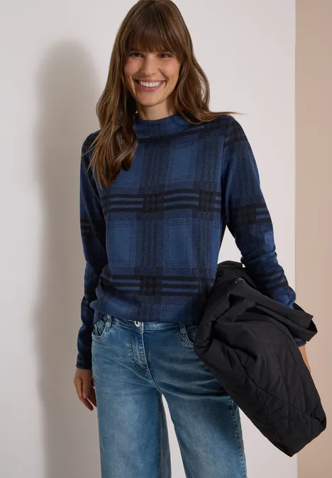 Shirt met lange mouwen, trechterhals en patroon urban dark blue melange Frau in blau-schwarz karierter Rollkragenbluse und Jeans lächelt, hält eine Jacke