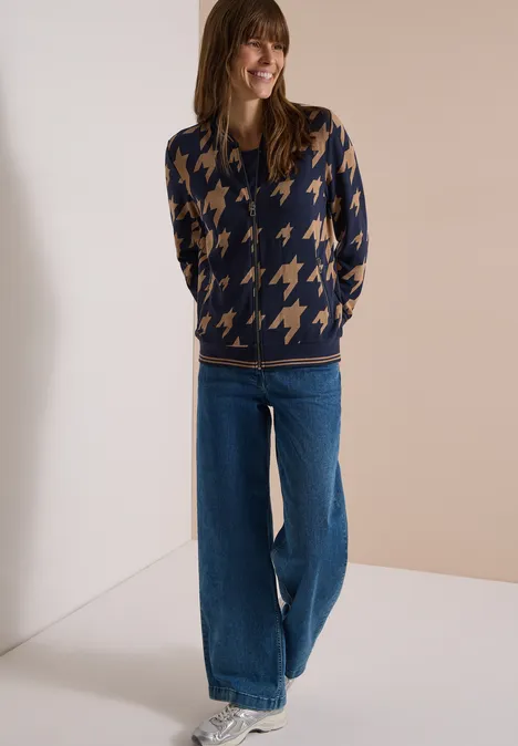 Leichter Blouson in Jacquard-Optik urban dark blue Frau trägt navyblauen Pullover mit beigem Hahnentrittmuster und weite Jeans vor neutralem Hintergrund.
