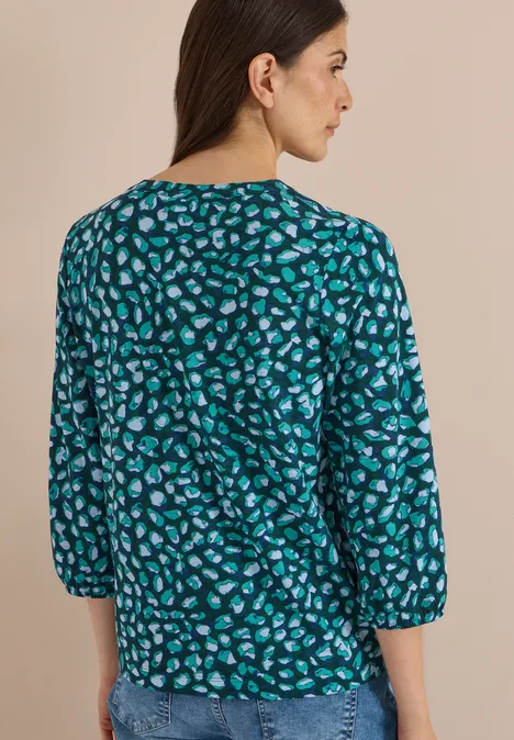Femme vue de dos en haut émeraude à motif abstrait de taches avec manches 3/4