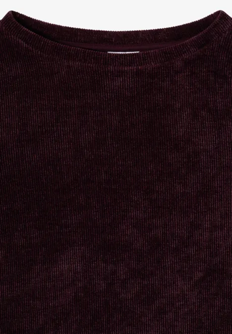 Ein dunkelroter, fein gerippter Pullover aus weichem Material.