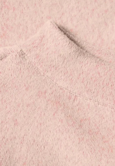 Nahaufnahme eines rosa flauschigen Strickpullovers.