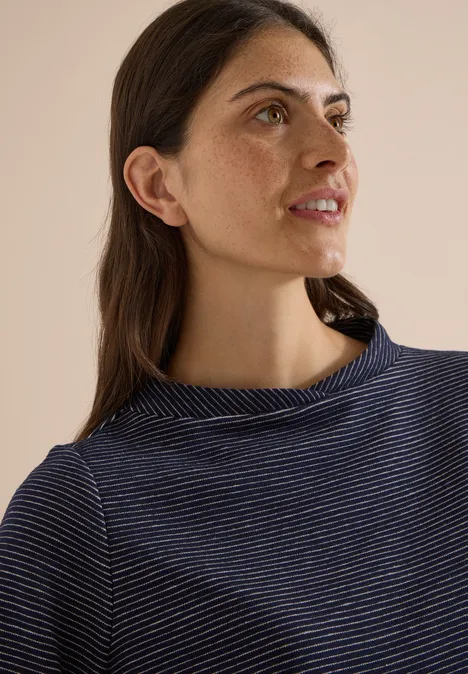 Ottoman Shirt im Two-Tone-Look urban dark blue Eine junge Frau mit braunen Haaren und gestreiftem Oberteil blickt seitlich und lächelt leicht vor hellem Hintergrund.
