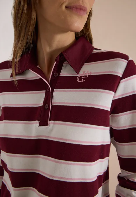 Frau trägt ein rot-weiß gestreiftes Poloshirt mit Kragen und Knopfleiste.