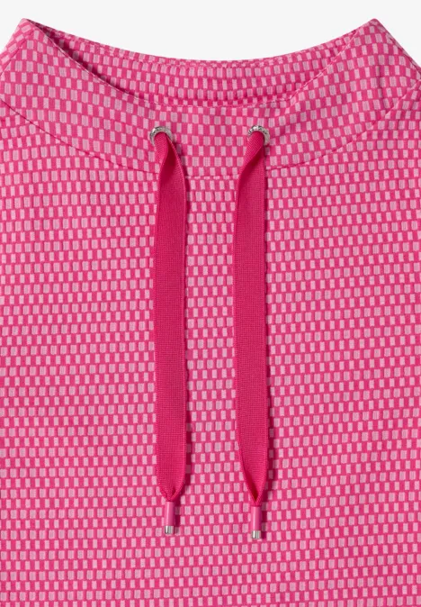 Nahaufnahme eines pinken, feinmaschigen Stoffes mit Kapuzenkordeln.