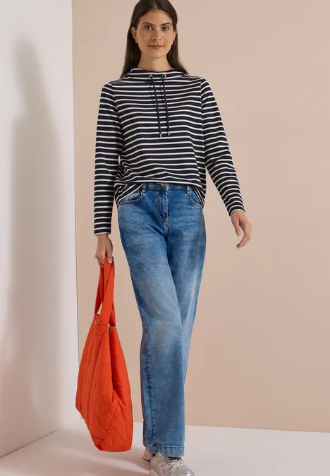 Langarm Shirt mit Funnel Neck und Streifen urban dark blue Frau in gestreiftem Pullover, weiten Jeans und orangefarbener Tasche vor heller Wand