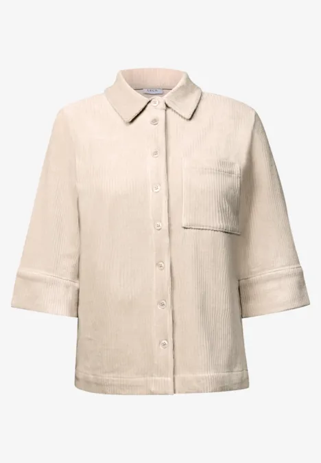 Chemise beige clair à manches 3/4, col classique, poche poitrine et patte de boutonnage épurée.