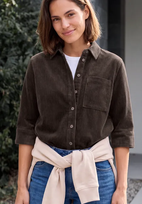 Jersey-corduroyblouse met halflange mouwen in effen kleur truffle brown Lächelnde Frau in braunem Cordhemd, Jeans und hellbeiger Strickjacke um die Taille im Freien.