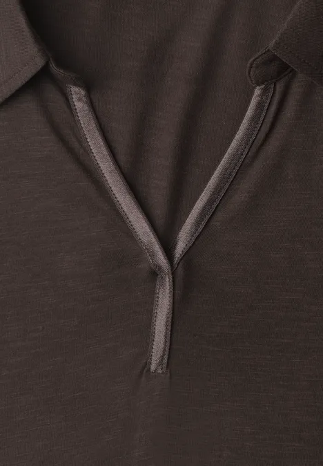 Nahaufnahme eines dunkelbraunen Poloshirt-Kragens mit offener Knopfleiste