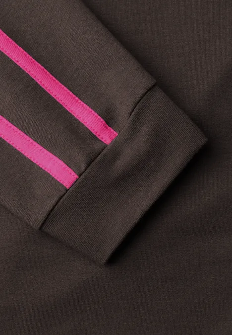 Nahaufnahme eines dunkelbraunen Sweatshirt-Ärmels mit zwei pinken Streifen am Bündchen.