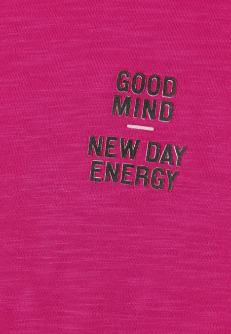 Roze stof met de opdruk 'GOOD MIND, NEW DAY ENERGY' in groene letters