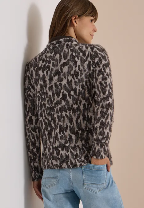 Langarm Shirt mit Fake-Kapuze truffle brown Frau trägt leo-gemusterten Strickcardigan und Jeans, steht seitlich vor hellem Hintergrund.