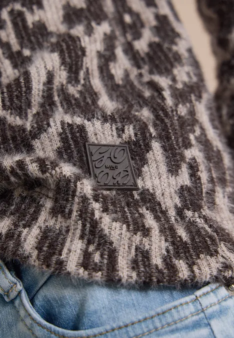 Langarm Shirt mit Fake-Kapuze truffle brown Nahaufnahme eines schwarz-weißen Strickpullovers mit abstraktem Muster und Leder-Label über Jeans.