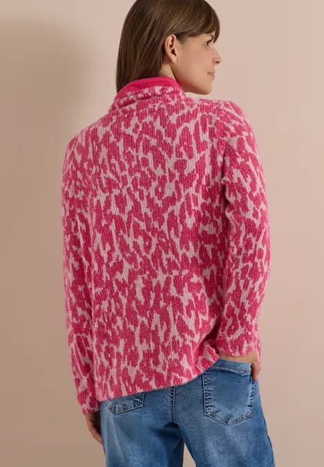Langarm Shirt mit Fake-Kapuze pink flash Frau von hinten in pink-weiß gemustertem Pullover und blauer Jeanshose, seitlich gewandt.