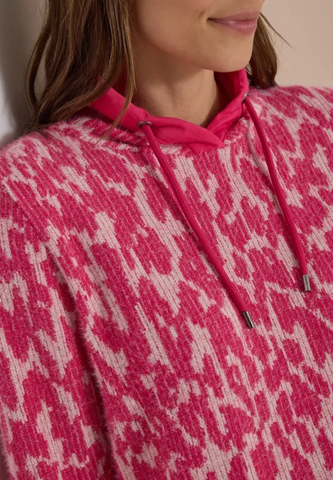 Langarm Shirt mit Fake-Kapuze pink flash Nahaufnahme einer Person im pinken Kapuzenpullover mit weißem abstrakten Muster.