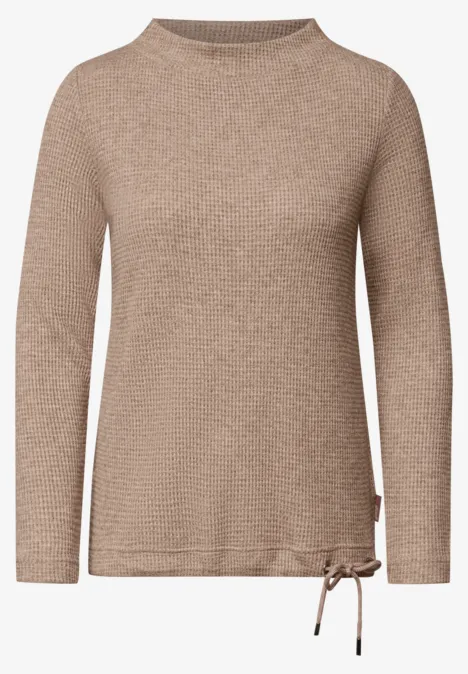 Pull beige clair à col rond, manches longues et petit nœud sur le côté.