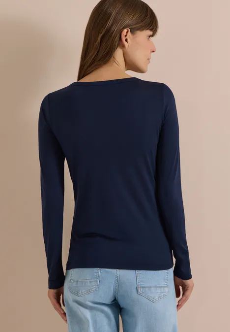 Langarm Shirt in Unifarbe mit Boat Neck urban dark blue Frau von hinten in dunkelblauem Langarmshirt und hellen Jeans vor neutralem Hintergrund.