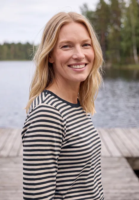 Langarm Shirt mit Boat Neck und Streifen urban dark blue Eine lächelnde blonde Frau in gestreiftem Shirt steht an einem Steg am See, umgeben von Wald.