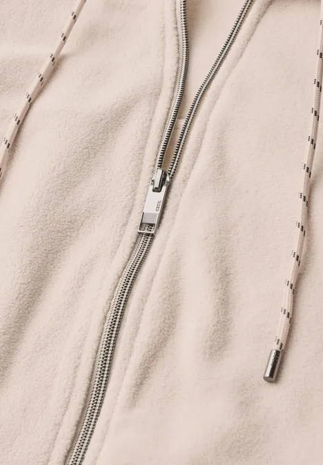 Langarm Fleece Jacke mit Kapuze cashmere beige Nahaufnahme eines hellbeigen Fleece-Hoodies mit Reißverschluss und Kapuzenkordeln.
