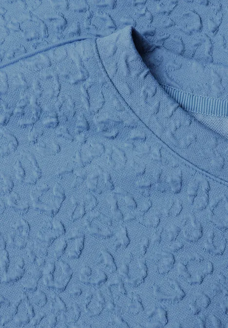 Tissu bleu clair texturé avec motif délicat et encolure ronde