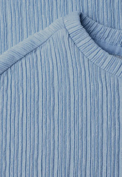 Gros plan sur un pull en maille côtelée bleu clair.