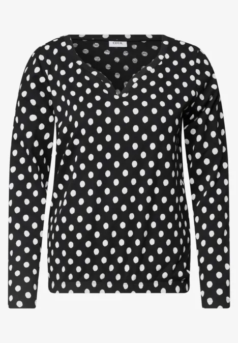 Schwarzes Langarmshirt mit weißen Punkten und V-Ausschnitt.