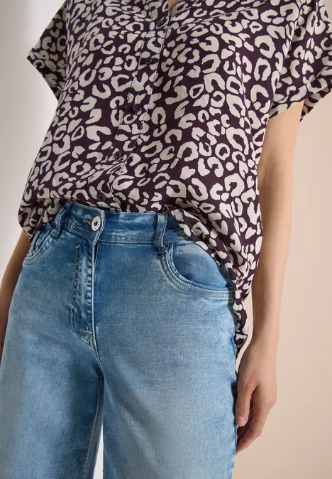 Leopardenmuster-Shirt und blaue Jeans in Oberkörperansicht.