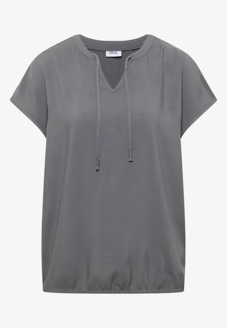 Graues Kurzarmshirt mit V-Ausschnitt und Kordeln sowie gesmoktem Bund, locker geschnitten.